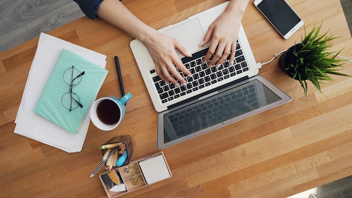 Escritorio con computador portátil y material de trabajo